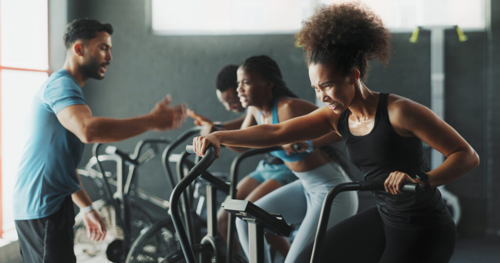 Een groep mensen in de sportschool cardio trainen onder begeleiding