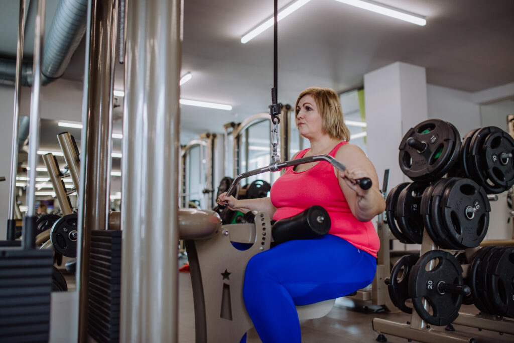 Een vrouw in de sportschool bezig met krachttraining om af te vallen