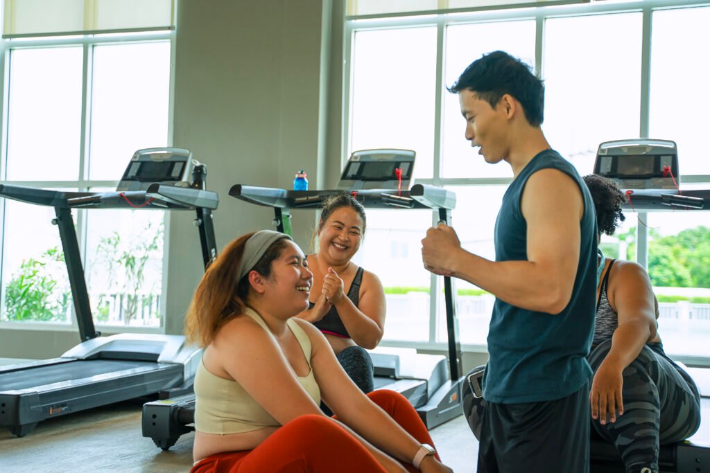 Twee vrouwen met overgewicht worden geadviseerd door een personal trainer