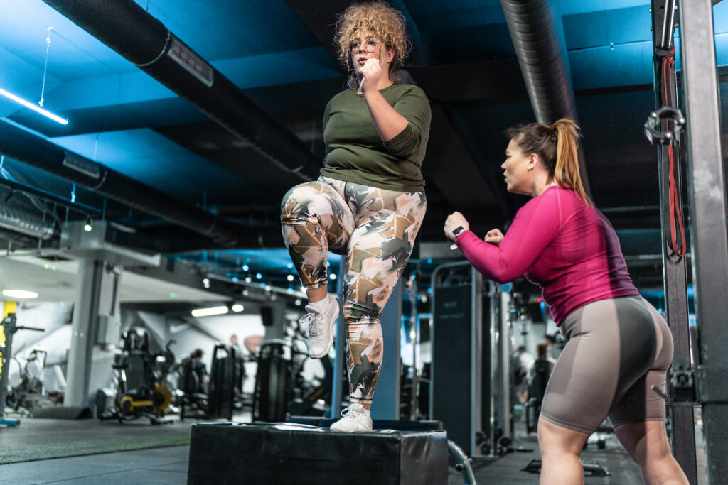 Vrouwen in de sportschool zijn elkaar aan het aanmoedigen om af te vallen